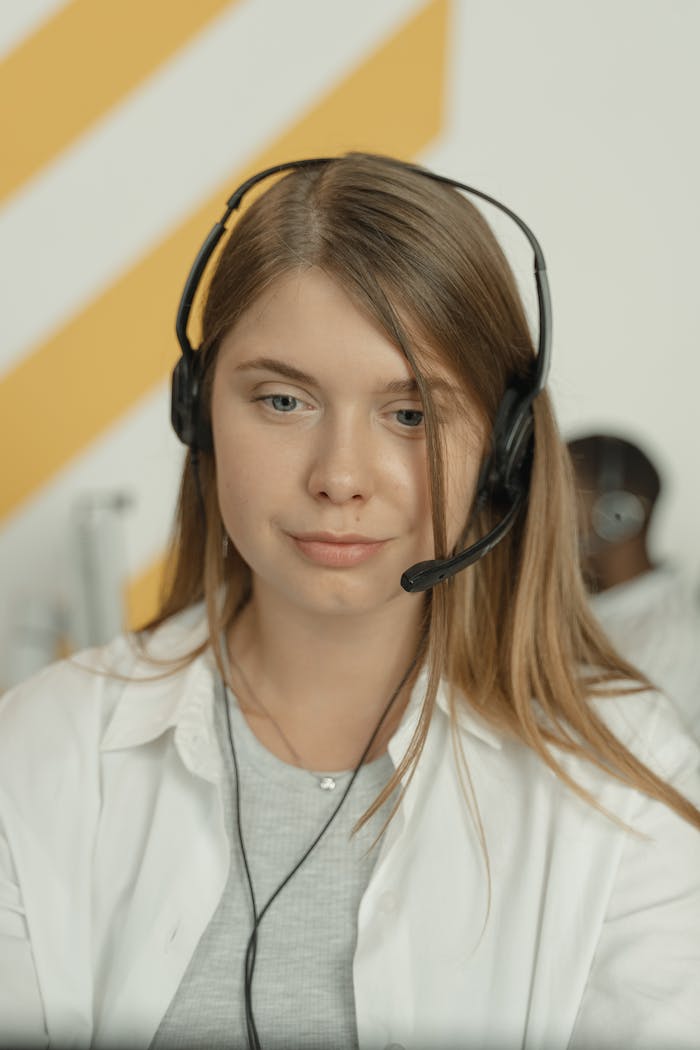 Professional woman wearing headphones, providing excellent customer service in a modern office setting.